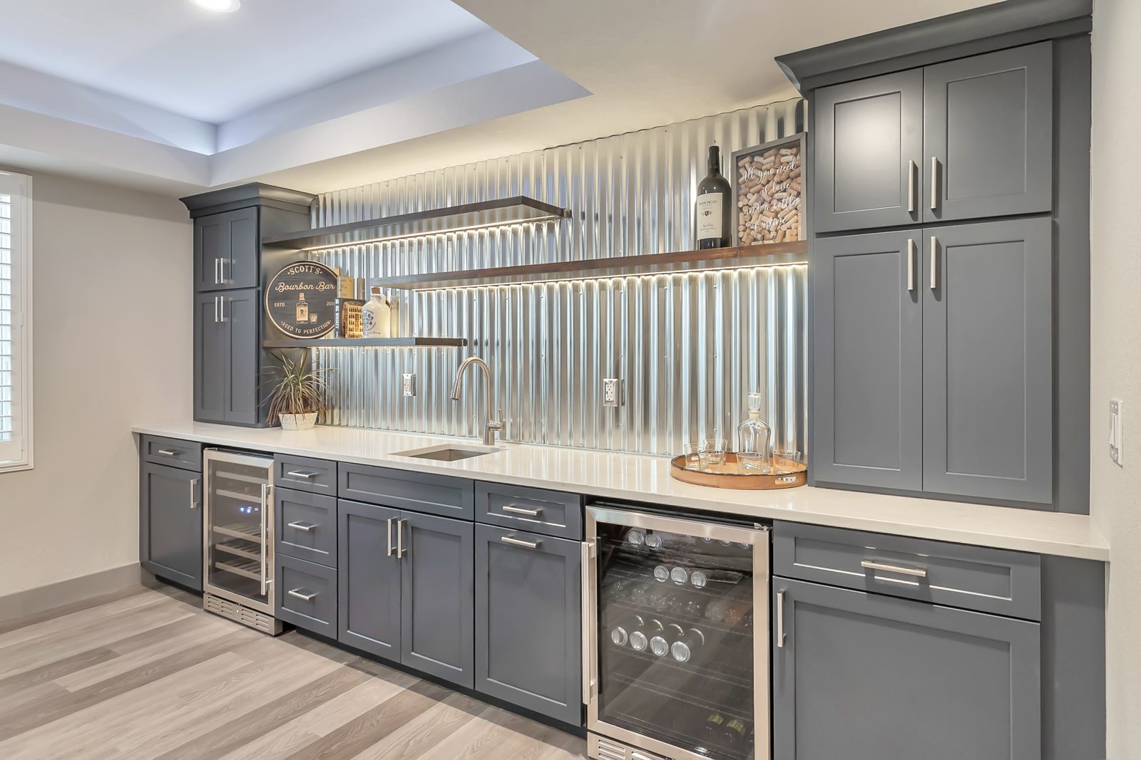 Finished basement bar with corrugated-metal backsplash and bar seating