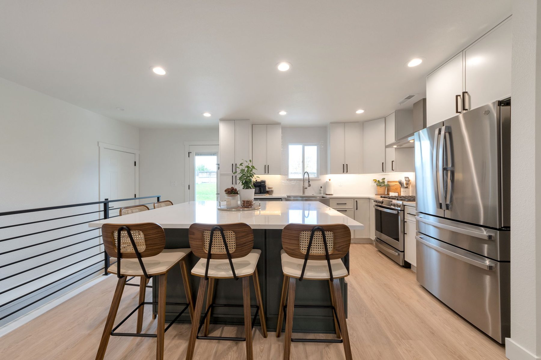 Open-concept kitchen with teal island and stainless appliances