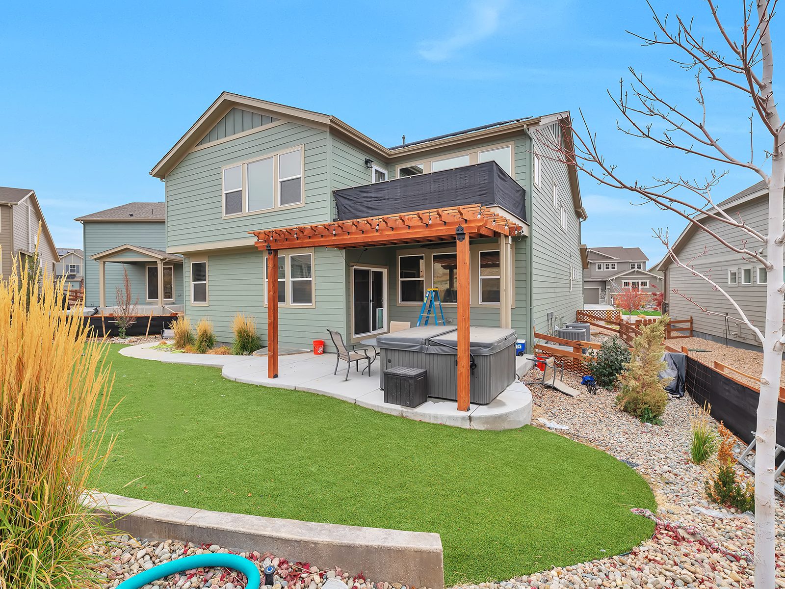 Backyard with covered deck, pergola, and hot tub overlooking the foothills