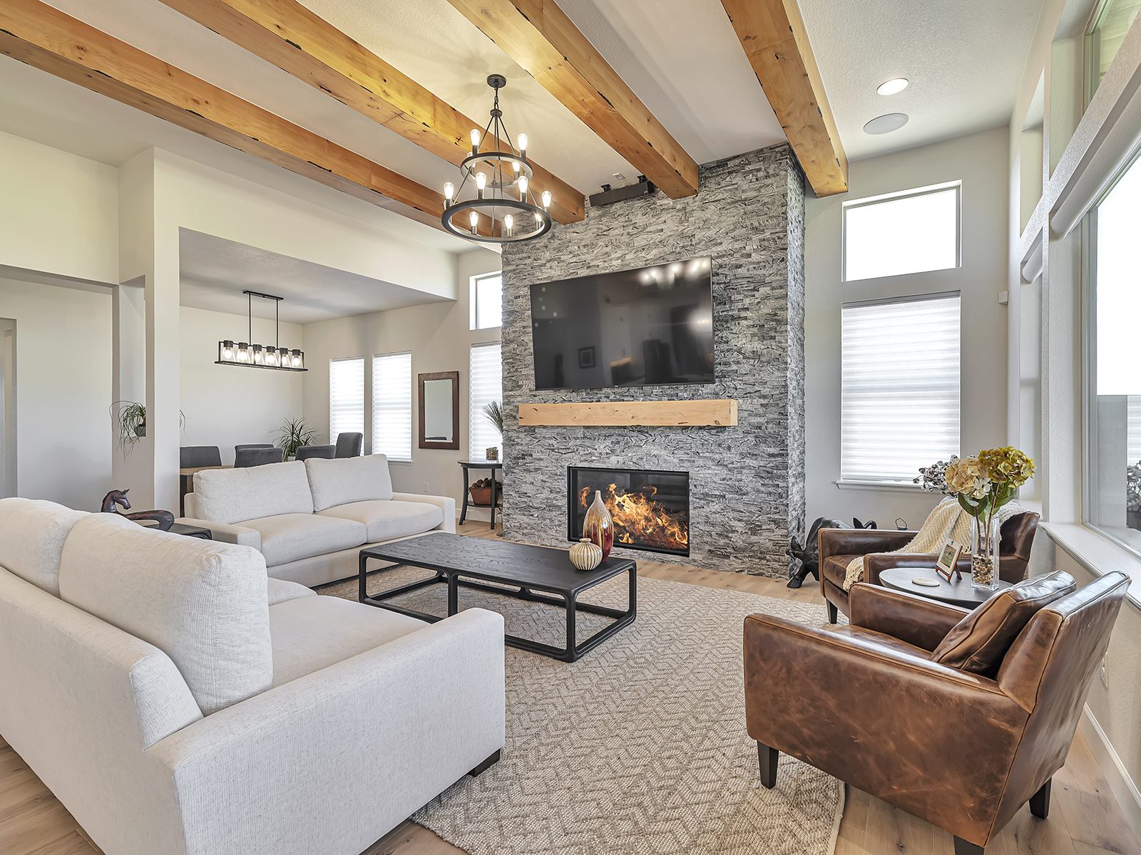 Great room with floor-to-ceiling stone fireplace and exposed wood beams
